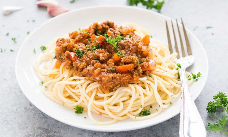 close up image of Bolognese sauce over spaghetti