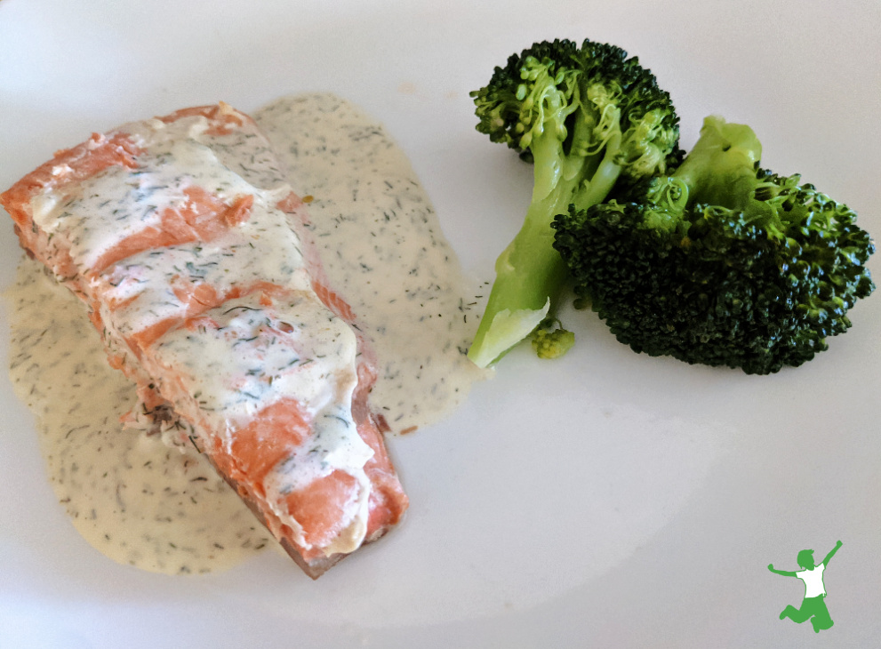 Salsa de eneldo casera saludable rociada sobre salmón y brócoli