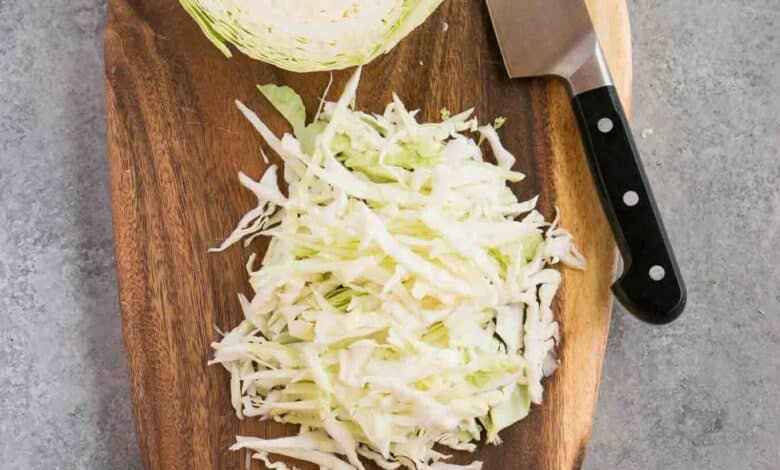 shredded cabbage on a cutting board and a knife