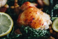 a picture of a chicken thigh in a zesty lemon sauce with potatoes, chickpeas and kale