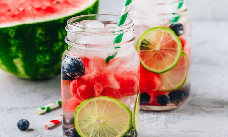 Infused fruit water with watermelon, lime and blueberry. Ice cold summer drink in glass mason jar
