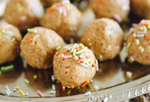 no-bake cake batter protein balls, covered in sprinkles on a silver platter.