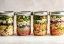 four mason jar salads in a row