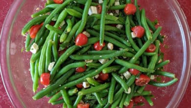 green bean and tomato "Christmas" salad in glass bowl on holiday tablecloth