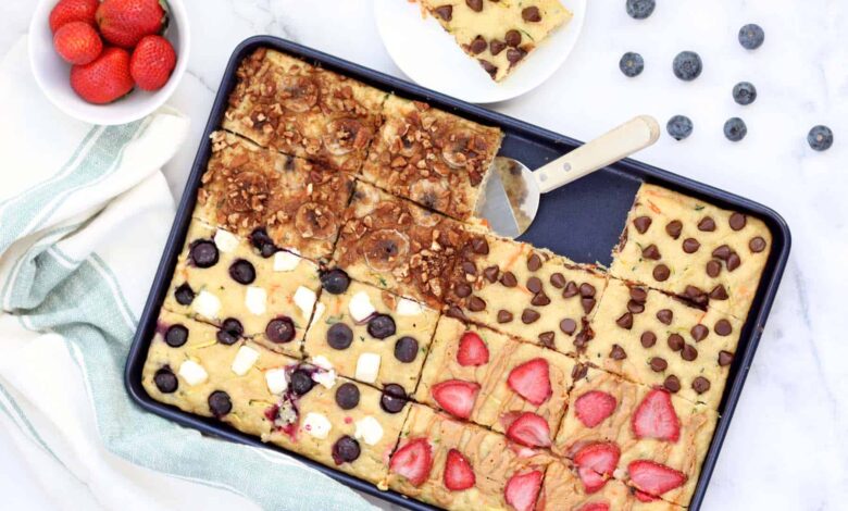 sheet pan pancakes in a blue baking sheet with assorted toppings