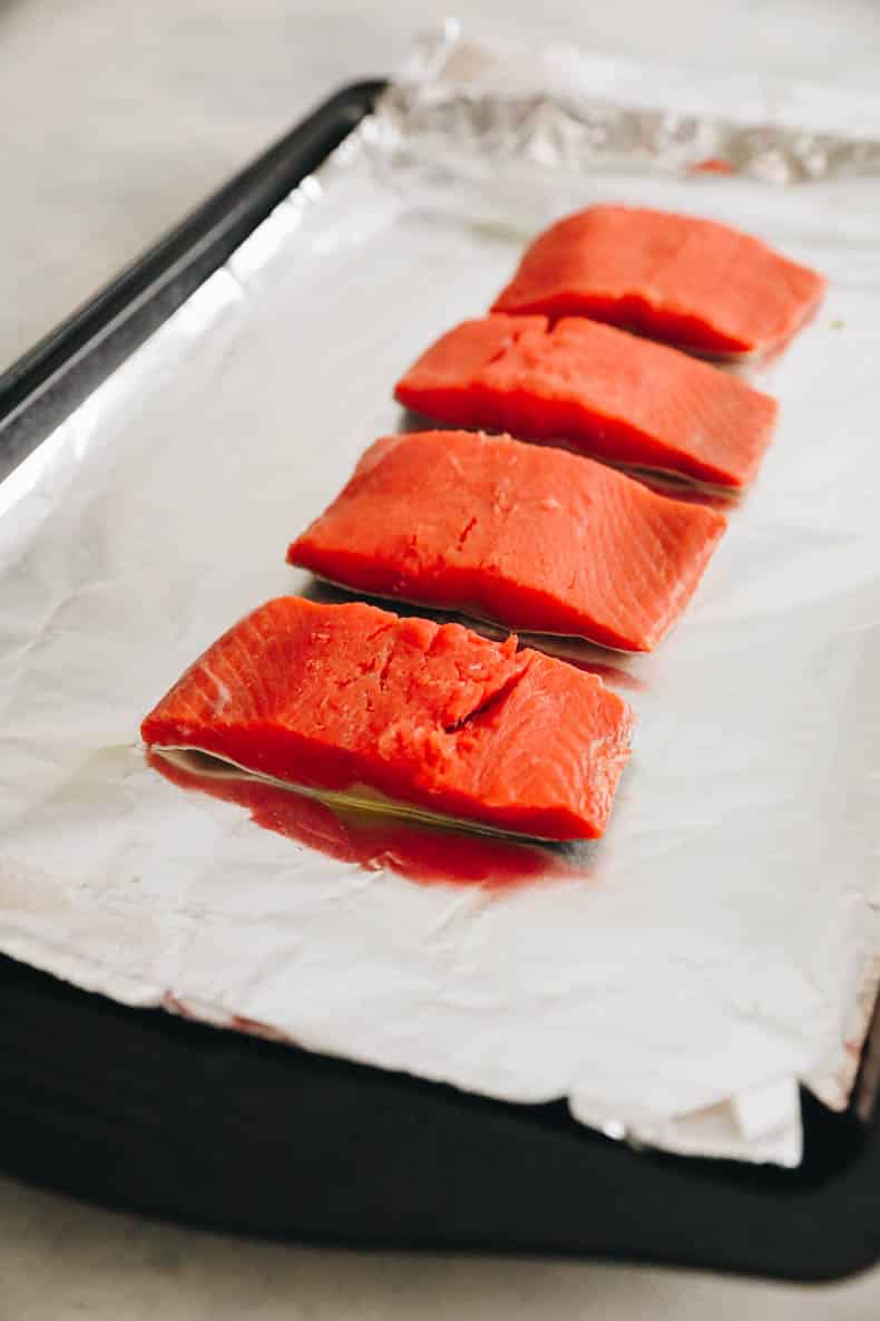 salmón fresco en una bandeja para hornear forrada con papel de aluminio