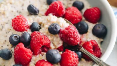 bowl of oatmeal with blueberries and raspberries and spoon.