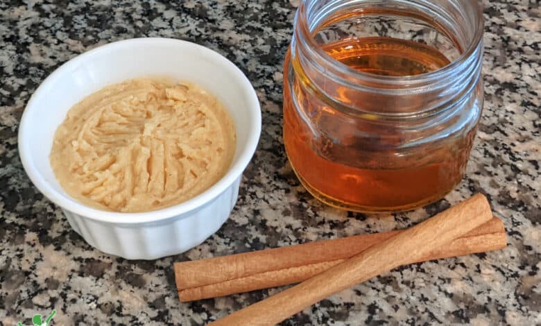 homemade cinnamon butter in small white bowl with honey and cinnamon sticks