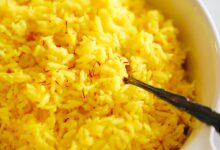 Close up shot of saffron rice in a serving dish.