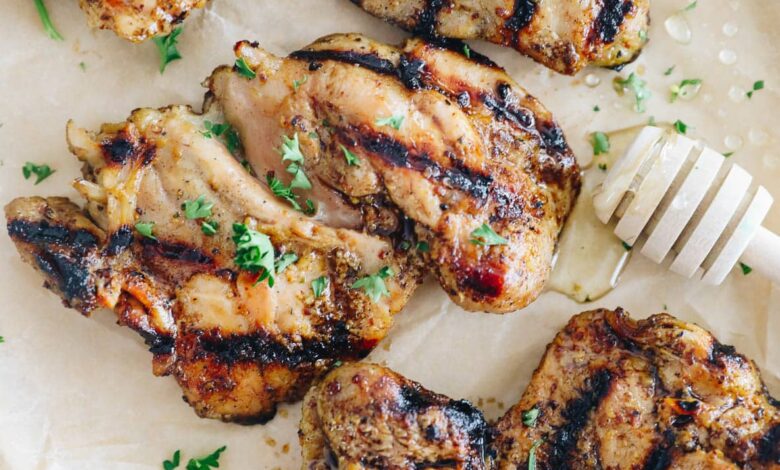 grilled honey mustard chicken on a plate sprinkled with parsley.