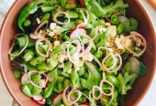 large brown bowl with spring mix salad.