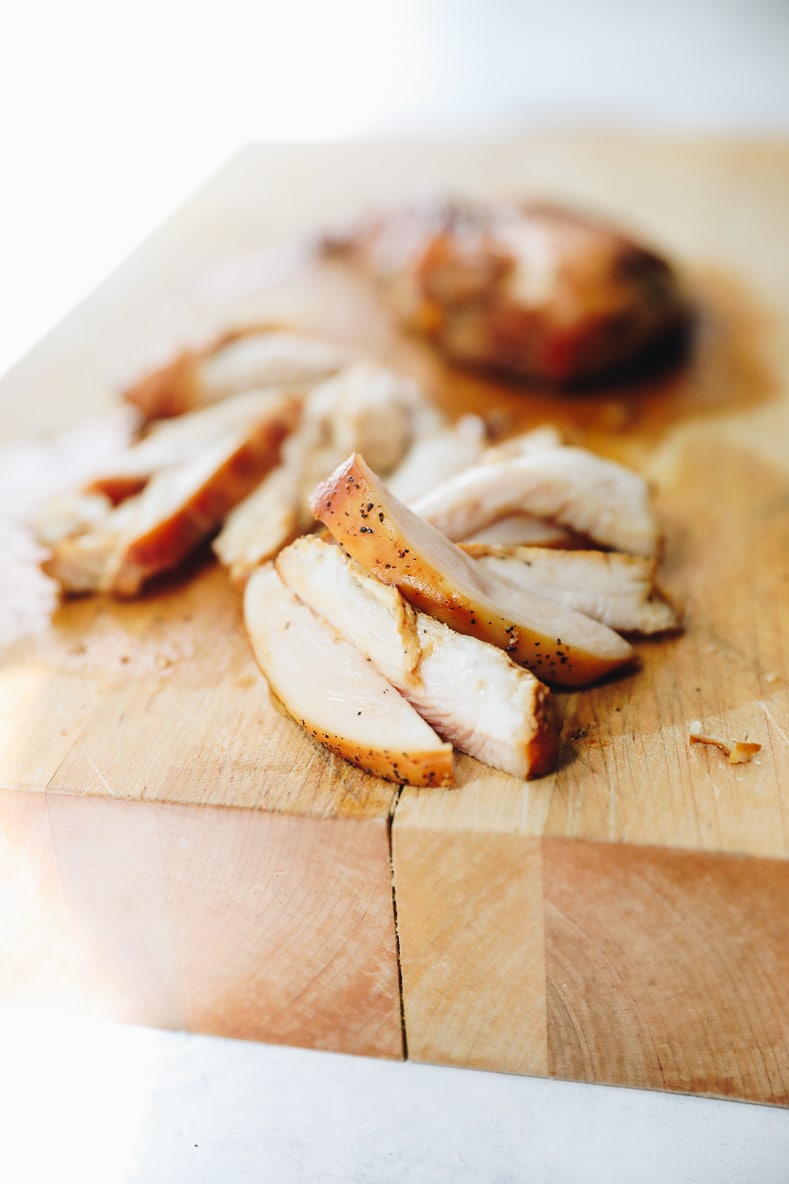 Pechuga de pollo cocida en una tabla de cortar.