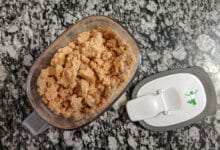 homemade peanut butter cereal in a container on granite table